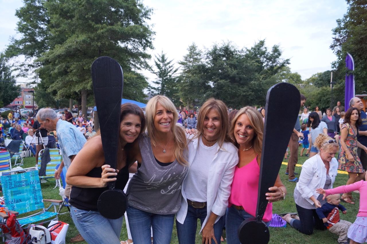 A group of women hold the two Share the Fun exclamation points.